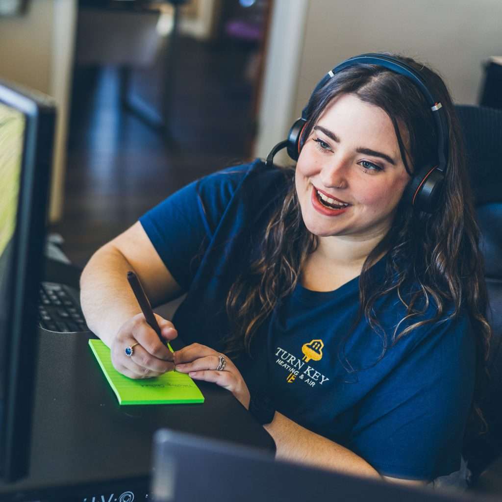 A Turn Key team member speaking on the phone in an office.